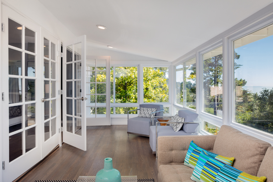Sunny room with lots of windows and laminate flooring. 