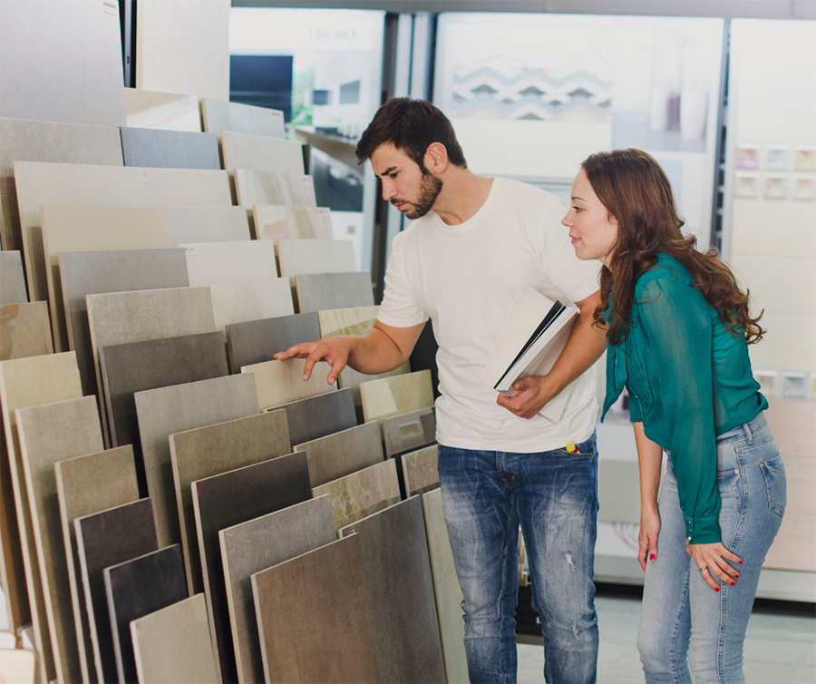 Couple in flooring store looking at samples of ceramic tile in different colors